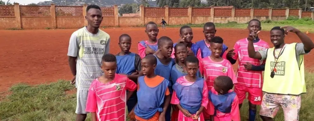 Fußballmannschaft des Soccer-Projekts in Kampala mit zwei Trainern